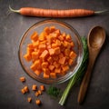 Dicing carrots in a glass bowl, top view. Carrots with knife and wooden spoon Royalty Free Stock Photo