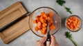 Dicing carrots in a glass bowl, top view. Carrots with knife and wooden spoon Royalty Free Stock Photo