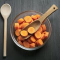 Dicing carrots in a glass bowl, top view. Carrots with knife and wooden spoon Royalty Free Stock Photo