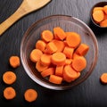 Dicing carrots in a glass bowl, top view. Carrots with knife and wooden spoon Royalty Free Stock Photo