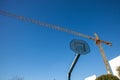A basketball hoop without a rim stands amidst the renovation of a school. In the background, a crane. Royalty Free Stock Photo