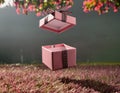Open gift box with pink ribbon on grass background. 3d rendering Royalty Free Stock Photo