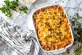 Cheesy cheese Potato Gratin Lasagne in white baking casserole on white marble table Royalty Free Stock Photo