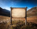 Blank wooden sign on a mountain with sky background Royalty Free Stock Photo