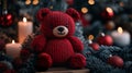 Christmastime concept. Red knitted bear toy sitting in front of a bunch of a Christmas background. Royalty Free Stock Photo