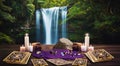 Deep green forest waterfall with a table in the foreground with gold tarot cards, lit candles, and amethyst crystals Royalty Free Stock Photo