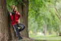 Explorer in Red Jacket Leaning Against a Tree Royalty Free Stock Photo