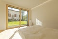 View of a bedroom with cardboard home staging furniture, a very bright window overlooking nature, green lawn and trees. Royalty Free Stock Photo
