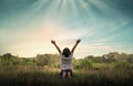 Praising the lord concept. Back view of a young girl with her arms raised to the sky in thankfulness and prayer Royalty Free Stock Photo