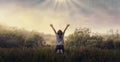 Praising the lord concept. Back view of a young girl with her arms raised to the sky in thankfulness and prayer Royalty Free Stock Photo