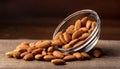 Almonds Almond Nuts Food. Raw almonds pouring out of a glass bowl onto a wood surface. Royalty Free Stock Photo