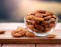Almonds Almond Nuts Food. Raw almonds pouring out of a glass bowl onto a wood surface. Royalty Free Stock Photo