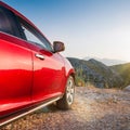 A new red car pulled over on the side of a remote mountain road Royalty Free Stock Photo