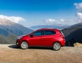 A new red car pulled over on the side of a remote mountain road Royalty Free Stock Photo