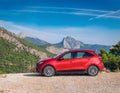 A new red car pulled over on the side of a remote mountain road Royalty Free Stock Photo