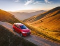 A new red car pulled over on the side of a remote mountain road Royalty Free Stock Photo