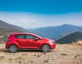 A new red car pulled over on the side of a remote mountain road Royalty Free Stock Photo