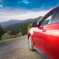 A new red car pulled over on the side of a remote mountain road Royalty Free Stock Photo