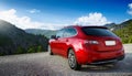 A new red car pulled over on the side of a remote mountain road Royalty Free Stock Photo