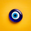 Evel eye bead, Turkish traditional amulet on yellow paper background. Royalty Free Stock Photo