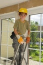 Little workman with security helmet on a ladder Royalty Free Stock Photo