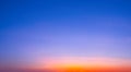 Dusk sky background with orange natural light with thin cloud on blue evening sky after sundown Royalty Free Stock Photo