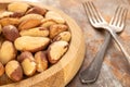 Generated Image. Brazil nuts without shells on a wooden plate on a rusty metal table, close-up. Royalty Free Stock Photo