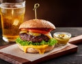 Tasty grilled cheeseburger served with lemonade and mustard. Barbecue hamburger with vegetables and meat Royalty Free Stock Photo