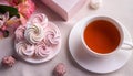 Airy and sweet handmade marshmallows on a white saucer next to a cup of tea and a box with a bouquet of marshmallow flowers. Royalty Free Stock Photo
