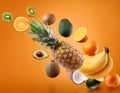 Many fresh tropical fruits falling on orange background Royalty Free Stock Photo