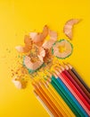 Color pencils with shavings. Directly Above Shot Of Colored Pencils With Shavings Over Yellow Background Royalty Free Stock Photo