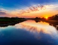 A wide river reflecting the colors of the sunset Royalty Free Stock Photo
