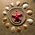 A sun with rays is drawn on the sand, and a sea red star was placed. Sun, rays, travel, starfish. Royalty Free Stock Photo