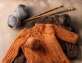 Knitted sweaters with knitting needles and wool in basket Royalty Free Stock Photo