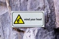 Sign warning mind your head attached to cave wall. Royalty Free Stock Photo