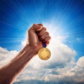 Success. Male hand rise up a gold medal against the dramatic sky with copy space Royalty Free Stock Photo