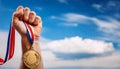Success. Male hand rise up a gold medal against the dramatic sky with copy space Royalty Free Stock Photo