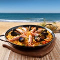 Spanish paella on the beach. A typical spanish paella with seafood in a paellera, the paella pan, on the beach Royalty Free Stock Photo