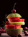 An arrangement of stacked fruit segments is balanced on a wooden surface. Generated image Royalty Free Stock Photo