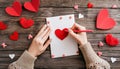 Hand of girl writing love letter on Valentine Day. Handmade red heart postcard. Woman write Royalty Free Stock Photo