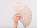 Womans manicured hand with fan against white background Royalty Free Stock Photo