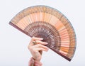 Womans manicured hand with fan against white background Royalty Free Stock Photo