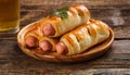 Pigs in a planket. Puff pastry rolls with sausages on a wooden background. Fast food or beer Royalty Free Stock Photo