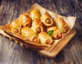 Pigs in a planket. Puff pastry rolls with sausages on a wooden background. Fast food or beer Royalty Free Stock Photo
