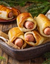 Pigs in a planket. Puff pastry rolls with sausages on a wooden background. Fast food or beer Royalty Free Stock Photo