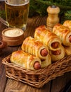 Pigs in a planket. Puff pastry rolls with sausages on a wooden background. Fast food or beer Royalty Free Stock Photo