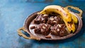 Chocolate banana date dread on a vintage tray on a blue stone background. Copy space. Royalty Free Stock Photo