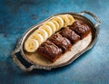 Chocolate banana date dread on a vintage tray on a blue stone background. Copy space. Royalty Free Stock Photo
