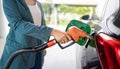 close up of a hand holding a gas pump, A hand is holding a fuel injector inserted into a car fuel tank Royalty Free Stock Photo