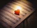 Love Music. Light heart on vintage music sheet Royalty Free Stock Photo